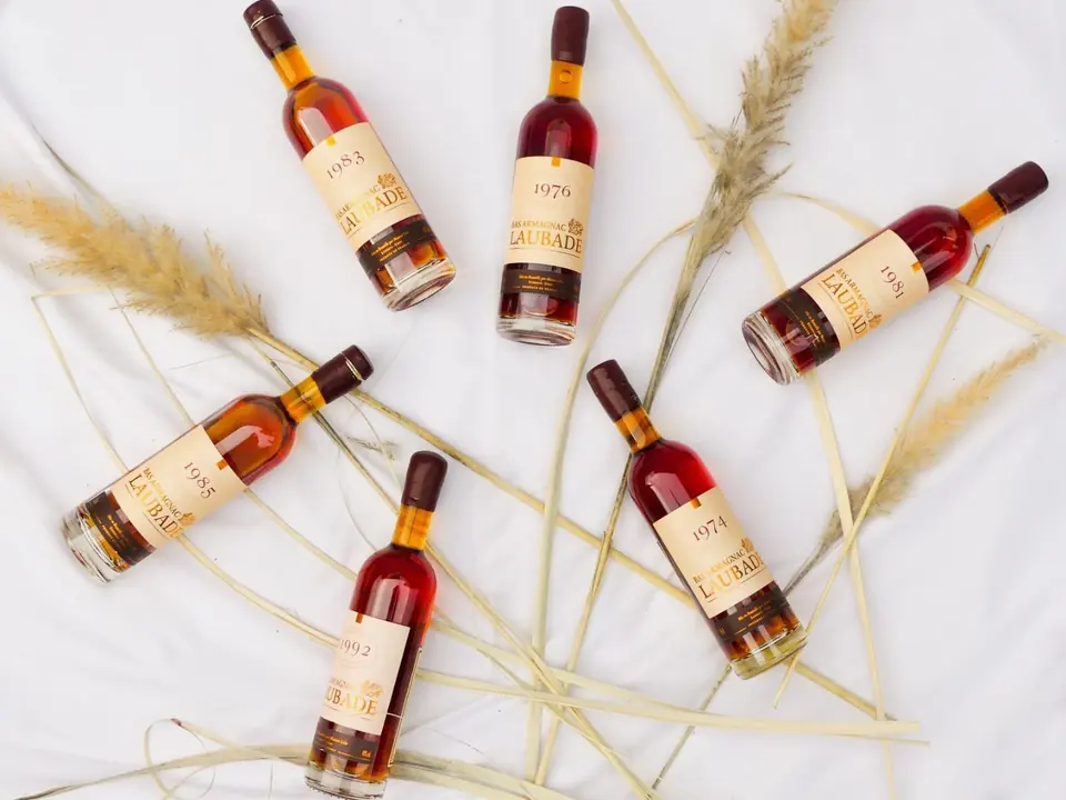 Petites bouteilles de liqueur posées parmi des épis de blé
